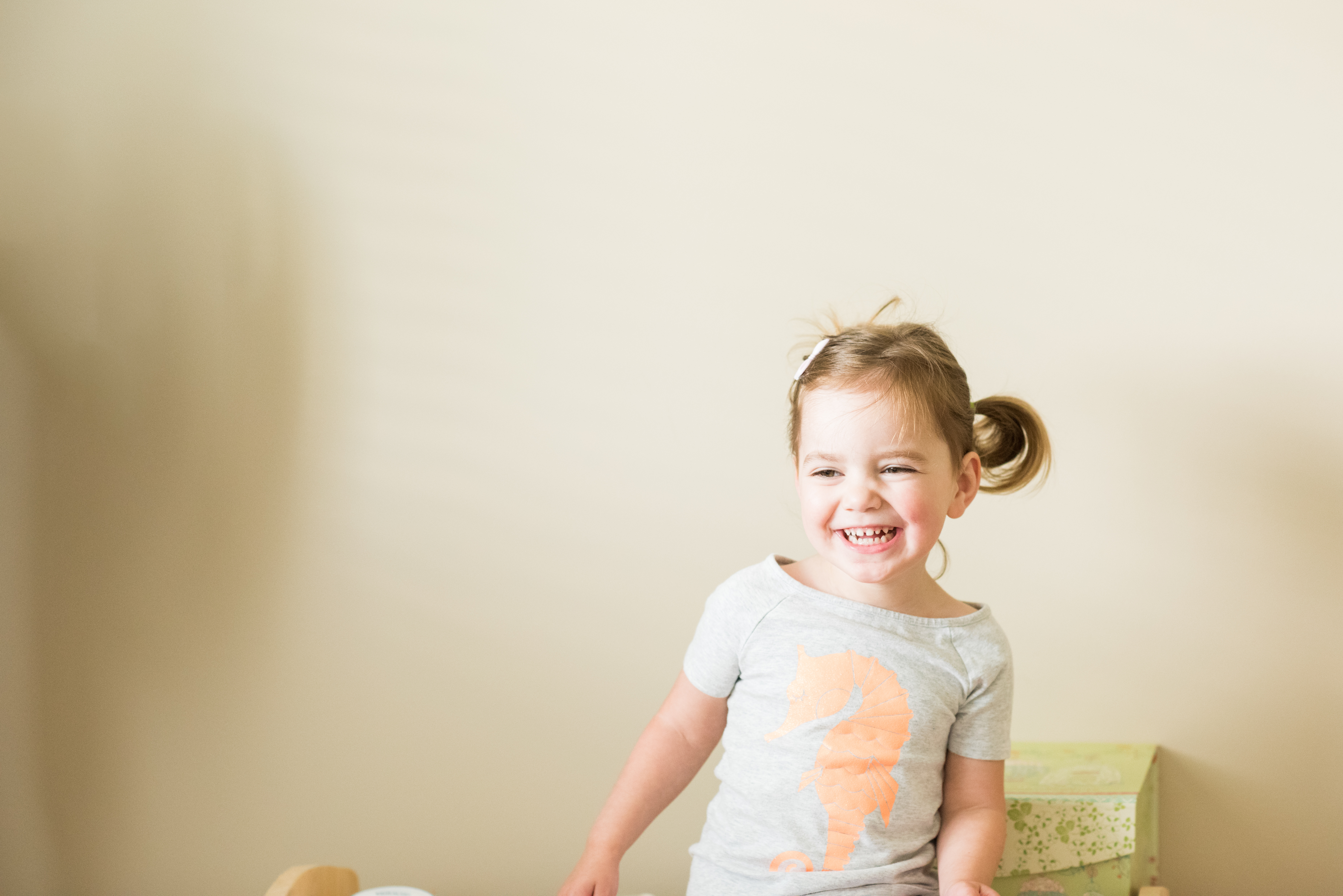 Happy young girl with pigtails in front of neutral background
