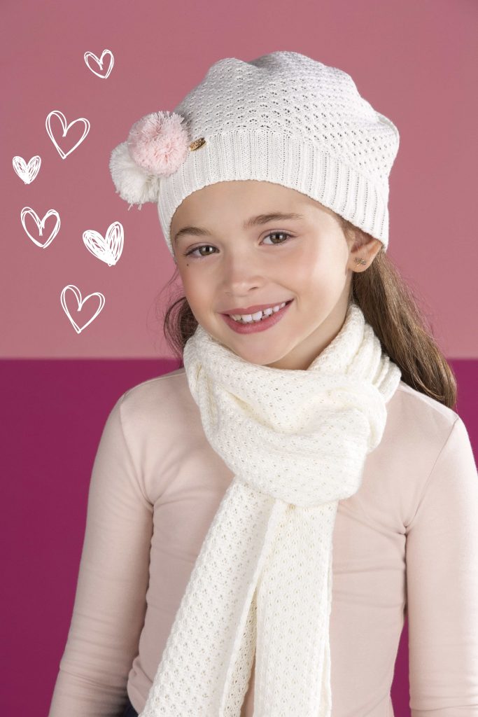 Modelo infantil com boina e cachecol brancos e blusa de inverno rosa clara